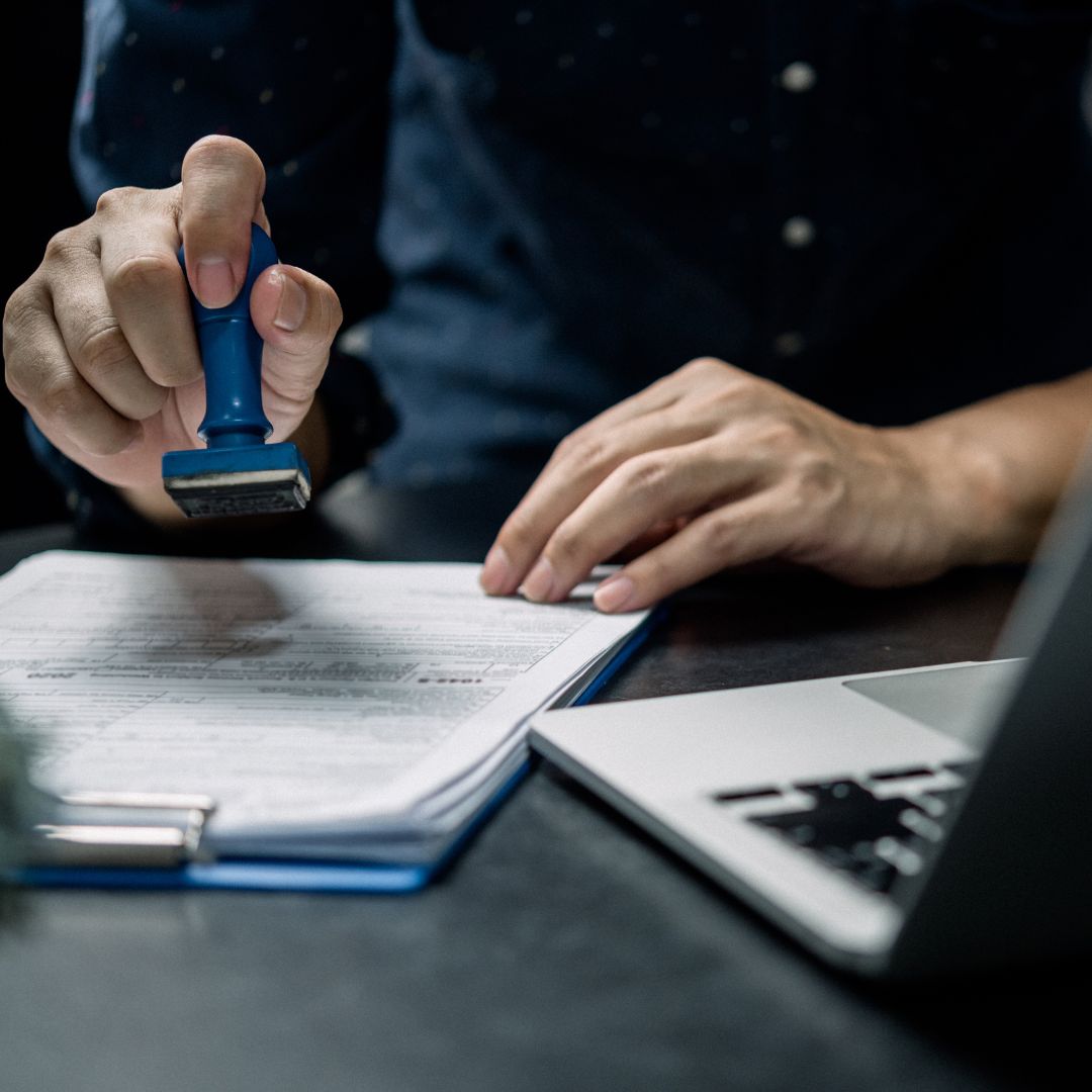 a person looking at forms with a stamp in their hands