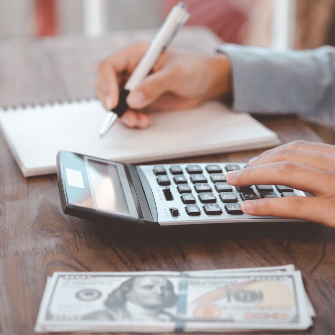 a person working on a calculator with money next to them